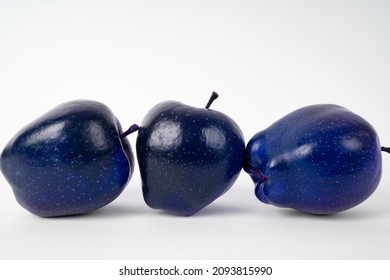 白い背景の上の 3 つの青いリンゴ