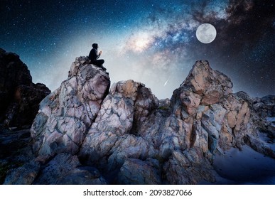 persona en la roca al aire libre meditando o rezando por la noche bajo la Vía Láctea y la Luna llena