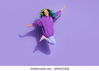 陽気な女性のジャンプ アップの完全な長さの写真は、飛んでいる鳥が紫の色の背景に分離された腕の翼を保持していると想像してください