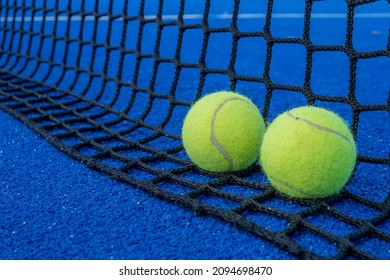 Red de una pista de pádel azul y dos pelotas. Concepto de deportes de raqueta.