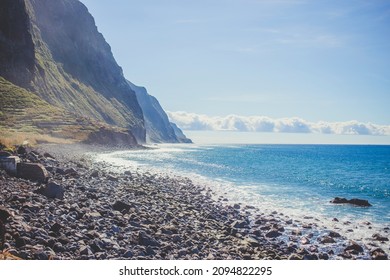 Versteckter felsiger Strand auf der Insel Madeira. Blick auf die Klippen und die Felsenküste. Wunderschöne Landschaft und türkisfarbene Meeresfarbe. Sommerzeit in Portugal.