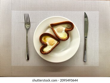 14 Desayuno de San Valentín. Huevo frito dentro de salchicha en forma de corazón en un plato blanco. Huevos de gallina fritos para el desayuno. Un delicioso plato de huevos con yema y proteína. foto de alta calidad