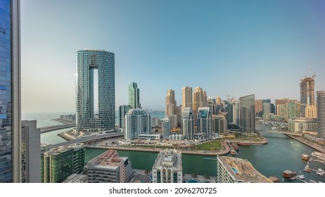 Tòa nhà chọc trời Dubai Marina và toàn cảnh quận JBR với các tòa nhà và khu nghỉ dưỡng sang trọng theo thời gian trên không. Bờ sông với những cây cọ và thuyền trôi trên kênh