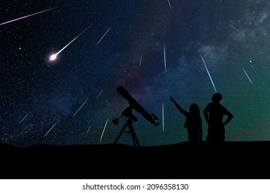 Silhouetten van vader, dochter en astronomische telescoop onder de sterrenhemel.