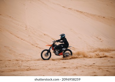 Motorcyclists at the dirt bike going fast at the dune 