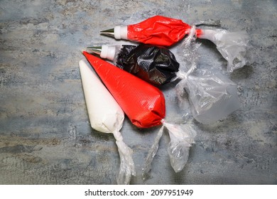 Red, white and black royal icing in piping bags with different consistencies for piping and flooding.