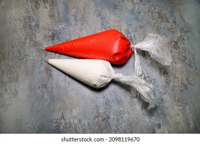 Two pastry bags with red and white royal icing.