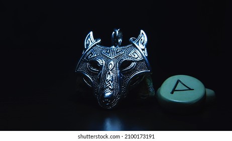 Zilveren amulet wolf hoofd runen in de donkere Vikingen, mystieke achtergrond