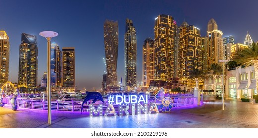 Dubai Marina logo y Harbour skyline arquitectura riqueza panorama de viajes de lujo por la noche en los Emiratos Árabes Unidos modernos