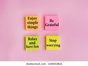 シンプルなことを楽しんだり、感謝したり、リラックスしたり、楽しんだり、ピンクの背景に付箋に書かれた言葉を心配するのをやめたり.ポジティブシンキング、モチベーションのコンセプト