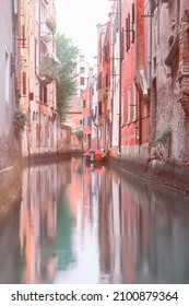 Kênh Venice lúc bình minh, những ngôi nhà màu đỏ và xanh phản chiếu trong làn nước tĩnh lặng. Ánh sáng ban mai hồng, không có ai xung quanh. Bối cảnh lãng mạn được chụp ở Venice, Ý.