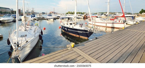 Perahu layar dan pemotong yang elegan dan modern ditambatkan ke dermaga di marina kapal pesiar pusat di Helsinki, Finlandia. Liburan musim panas, kapal pesiar, rekreasi, olahraga, lomba layar, aktivitas waktu luang, layanan, pariwisata