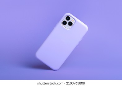 紫色のシリコンケースの iPhone 11 および 12 Pro max が背面図に倒れ、紫色の背景ビューに分離された電話ケースのモックアップは、2022 年頃の色を表示します