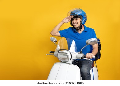 Leveringsmand iført blå uniform kørende motorcykel og leveringsboks isoleret på gul baggrund. Motorcykel levering af mad eller pakkeekspresservice