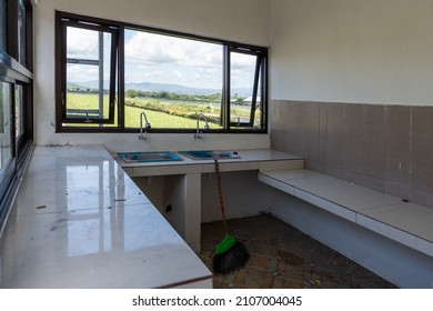 Fregadero abandonado con dos grifos y una ventana con vistas a los campos de arroz. Lavabo de diseño con paisaje natural. Arquitectura de cocina minimalista con concepto de naturaleza.
