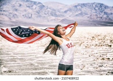 American flag woman USA sport athlete winner cheering waving stars and stripes outdoor after in desert nature. Beautiful cheering happy young multicultural girl joyful and excited.