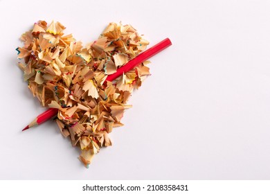 Het hart van potloodkrullen is doorboord met een rood potlood als een pijl. Valentijnsdag.