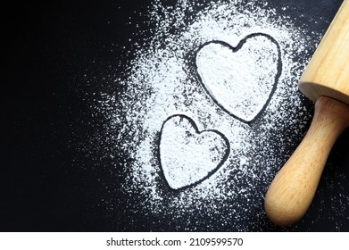 Herz aus Mehl und Nudelholz auf dunklem Küchentisch mit Platz für Text oder Bilder. Valentinstag oder Muttertagskonzept