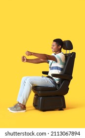 Afro-Amerikaanse man in autostoeltje en met denkbeeldige stuurwiel op kleur achtergrond