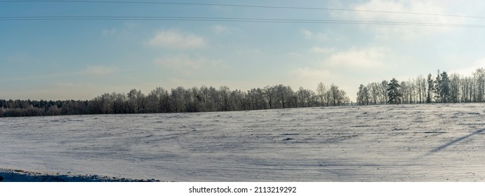 Paisaje de tierras de cultivo de invierno paisaje bajo la nieve con árboles en el fondo. Paisaje invernal con campo cubierto de nieve. Espacio para texto.