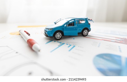 Vue de face d'une petite voiture bleue sur des dessins de feuilles