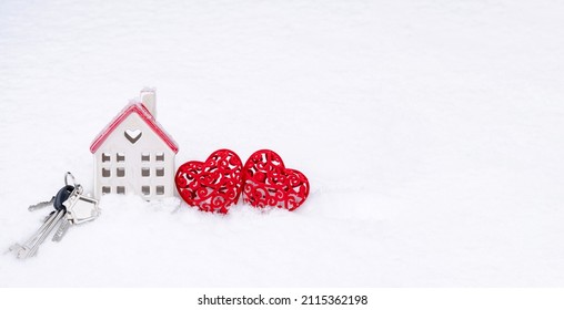 Um molho de chaves de casa e dois corações na neve - Dia dos Namorados, amor em casa. Moradia de casal, imóveis, aluguel, hipoteca, realocação. Conforto e aconchego no ninho de amor.