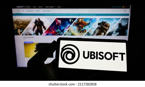 STUTTGART, DUITSLAND - 07 jan. 2022: Persoon met mobiele telefoon met logo van het Franse videogamebedrijf Ubisoft Entertainment SA op het scherm voor webpagina Focus op telefoondisplay