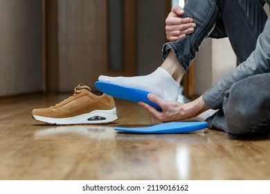 新しいカスタム インソールを靴に入れる男性。足のレクリエーション医学の概念