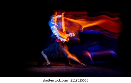 Năng lượng. Chân dung năng động của các vũ công khiêu vũ trẻ đang nhảy điệu tango Argentina bị cô lập trên nền tối với ánh sáng hỗn hợp neon. Khái niệm về nghệ thuật, vẻ đẹp, sự duyên dáng, hành động, cảm xúc. Sao chép không gian cho quảng cáo