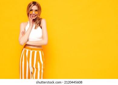Retrato de joven hermosa mujer rubia sonriente en ropa de verano de moda. mujer despreocupada posando junto a la pared amarilla en el estudio. Modelo positivo divirtiéndose en el interior. alegre y feliz