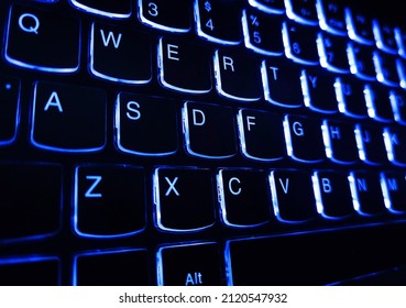 Bright multicolor macro black keyboard button background. Bright multicolor macro background flickering buttons black laptop keyboard. Modern blue iluminated backlit keyboard.  