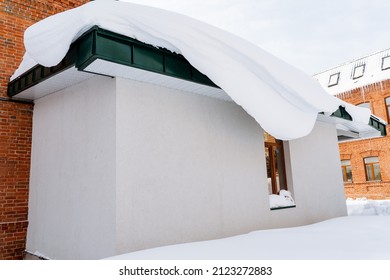 congère suspendue au toit.bloc de neige sur la façade du bâtiment.nettoyage des rues en hiver. Bâtiments de la ville sous la neige. L'hiver arrive.Photo de haute qualité
