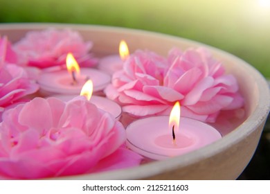 Lumânări de trandafiri.Lumânări aprinse roz și trandafiri roz în apă.Concept de aromaterapie și spa.Flacără de lumânare. Lumânări fundal. Set de lumânări aprinse