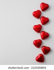 愛、ロマンス、バレンタインデーの背景 - コピー スペースで白い背景に赤い箔でハート形のチョコレート菓子