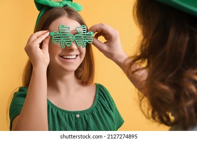 Pasangan muda mengenakan kacamata dengan latar belakang kuning. Perayaan Hari St. Patrick
