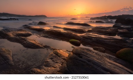 日没時の水、岩、石の美しい風景