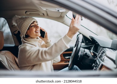 Mujer manejando en auto y usando teléfono