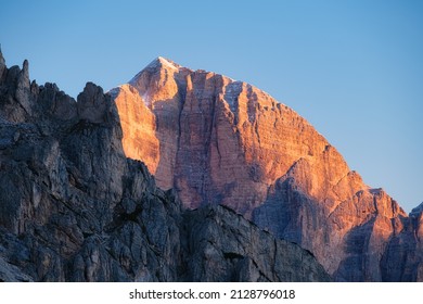 Tebing tinggi saat matahari terbenam. Alpen Dolomit, Italia. Pegunungan dan langit cerah. Pemandangan gunung dan tebing. Pemandangan alam pegunungan. Fotografi sebagai latar belakang perjalanan.