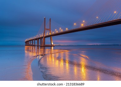 Natlys på Lissabon-broen. Vasco da Gama-broen er et vartegn og en af ​​de længste broer i verden. Bylandskab. Portugal er et fantastisk turistmål