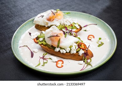Sarapan sehat telur benedict alpukat di atas roti panggang dengan sayuran di atas piring putih