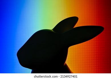 多色の背景にウサギの置物の黒いシルエットが描かれています