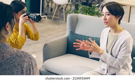 オフィスで話しているアジアの女性。インタビュー撮影。
