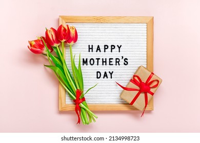 Filzplatte mit Text Happy Mother's Day, roter Tulpenstrauß auf rosafarbenem Hintergrund Gruß-Weihnachtskarte Flache Ansicht von oben