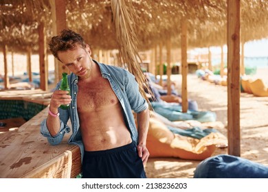 Shows body. Young european man have vacation and enjoying free time on the beach of sea.