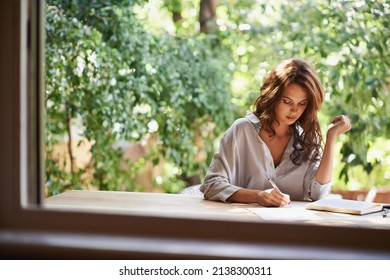 Shes going to become a famous writer. Shot of an attractive young woman writing in a relaxed environment outdoors.