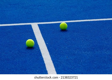 dos pelotas de pádel cerca de las líneas de una cancha de pádel azul, concepto de deportes de raqueta