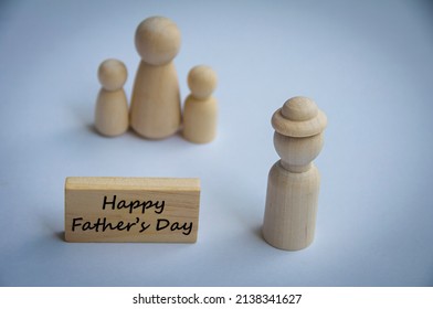Gelukkige vaderdag wenst tekst op houten blok met houten poppenmodel van een vader en familie. Gelukkig Vaderdagconcept