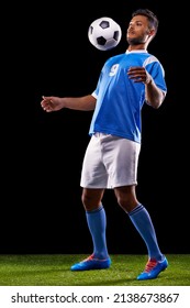 彼の胸のコントロールは完璧です。ハンサムな若いサッカー選手の全身スタジオショットが黒の背景に分離されています。