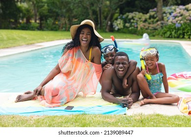 Porträt einer afroamerikanischen Familie, die lacht, während sie gemeinsam am Swimmingpool genießt. unverändert, Lifestyle, Kindheit, Spaß, Familie, Freizeit und Wochenendkonzept.