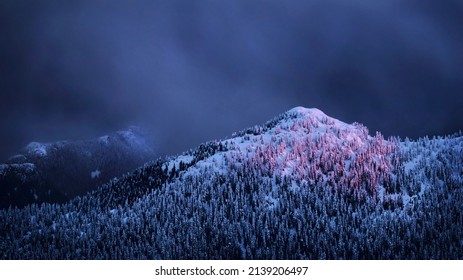 Pink Sonnenënnergang Liicht op de schneeweege Bierg ënner stiermeschen Himmel. Schéin dramatesch Vue vum Mt Seymour. Mt Seymour Ski Auswee. Vancouver. British Columbia. Kanada